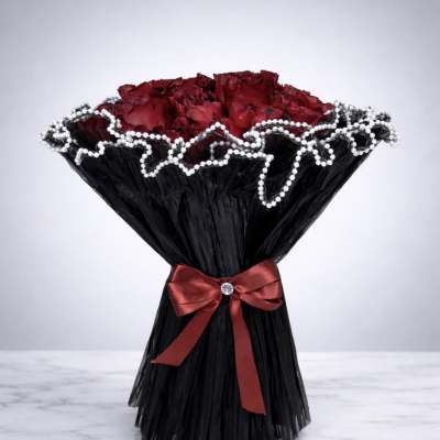 Bouquet of red roses wrapped in black paper with a red ribbon