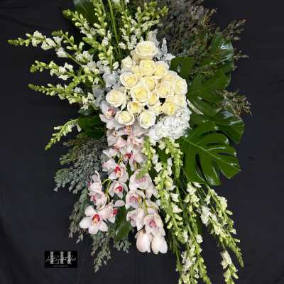 Tall floral spray with white roses, orchids, and snapdragons