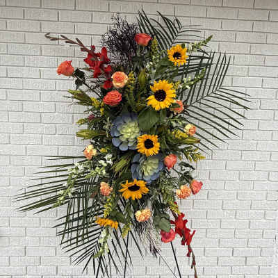 Tall floral standing spray with sunflowers, roses, and succulents