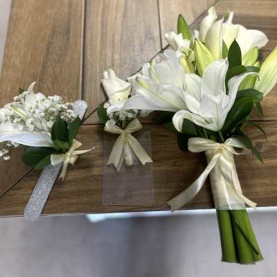 White lily bouquets with ribbon on a wooden table