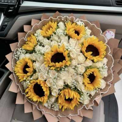 Bouquet of sunflowers and white roses wrapped in brown paper