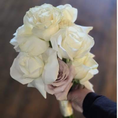 Handheld bouquet of white roses with a pale blush rose