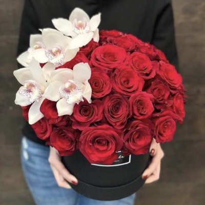 Red roses with white orchids in a black hat box