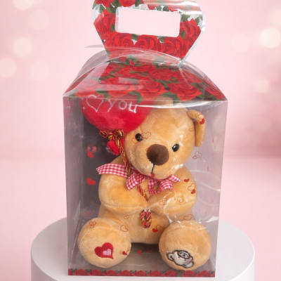 Teddy bear in a clear gift box with a red heart and rose-print top