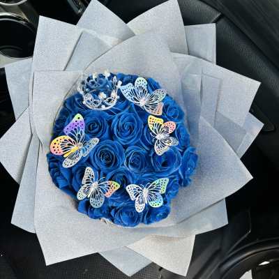 Blue rose bouquet with butterfly decorations and silver wrap