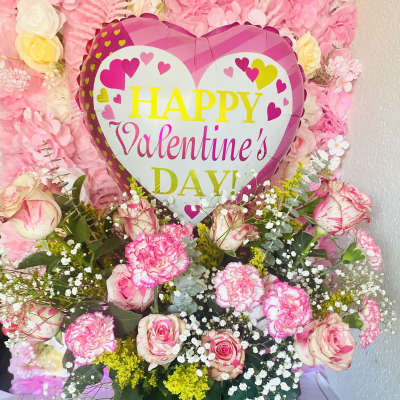 Pink floral arrangement with a heart-shaped Happy Valentine's Day balloon