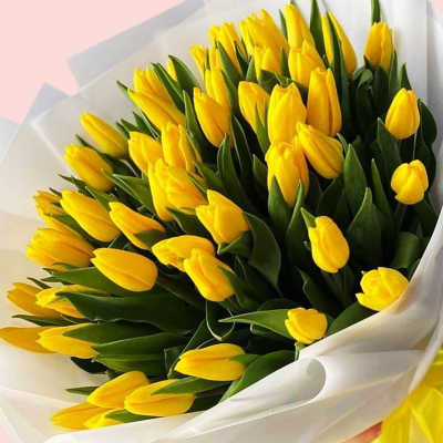 Bouquet of yellow tulips wrapped in white paper