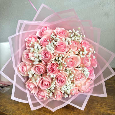 Pink rose bouquet wrapped in translucent pink paper