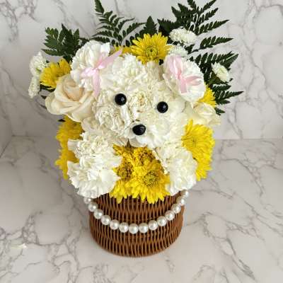 White and yellow flower arrangement in a wicker basket with a pearl trim
