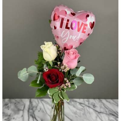 Roses in a glass vase with a pink heart balloon