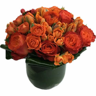 Orange bouquet of roses and tulips in a dark vase