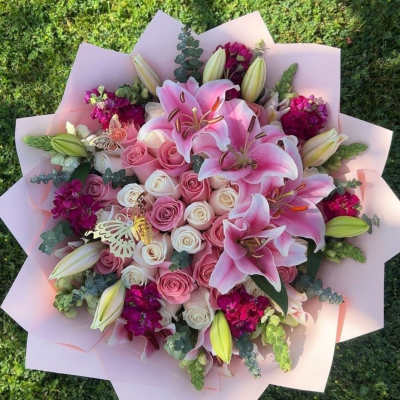 Pink lily and rose bouquet wrapped in pale pink paper