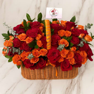 Basket of red and orange roses with greenery