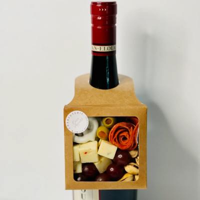 Wine bottle with a charcuterie box attached to the front