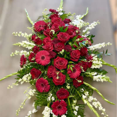 Red roses and pink gerbera daisies in a tall standing spray