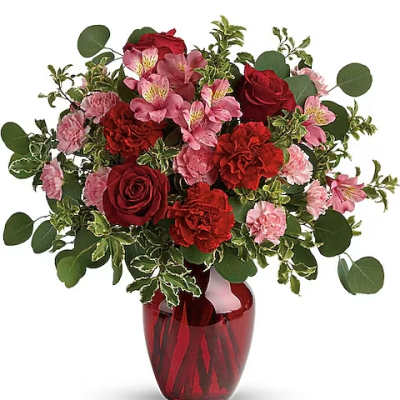 Red and pink flower bouquet in a red glass vase