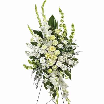 White floral standing spray on an easel with green accents