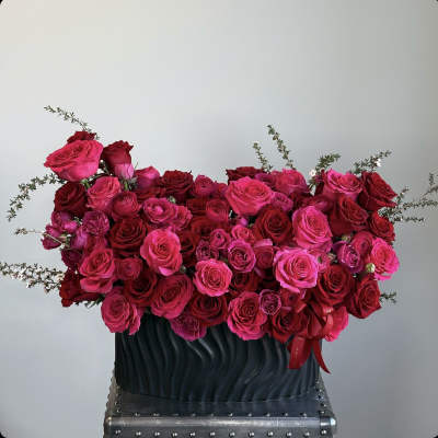 Large bouquet of pink and red roses in a dark vase