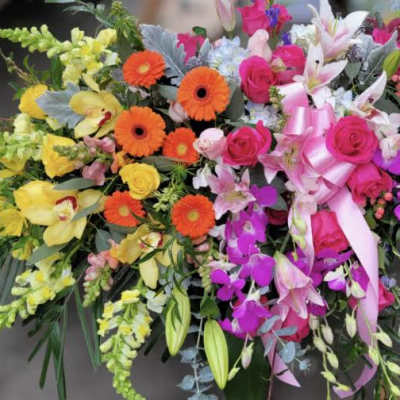 Colorful floral spray with roses, gerbera daisies, lilies, and orchids