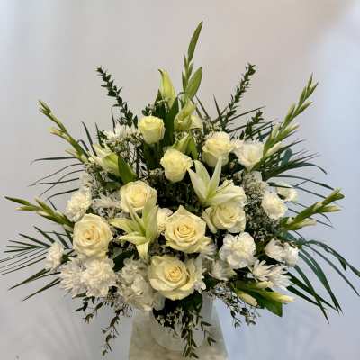 White roses and lilies arranged in a clear vase