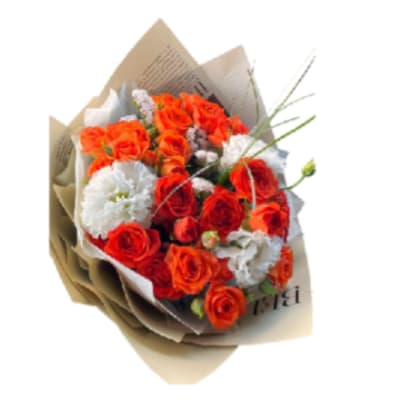 Bouquet of orange and white roses wrapped in brown paper