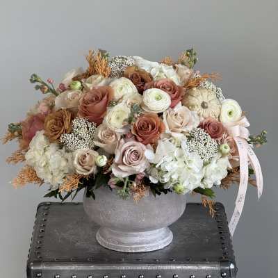 Large pastel rose and hydrangea arrangement in a gray urn
