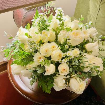 Bouquet of white roses with small white filler flowers and greenery