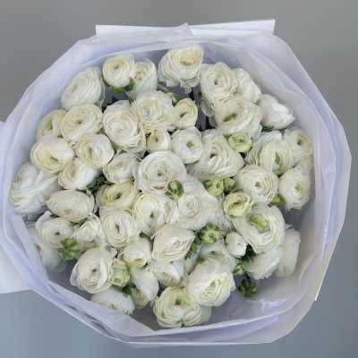 Bouquet of white ranunculus wrapped in pale paper