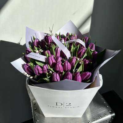 Bouquet of purple tulips wrapped in white and lavender paper