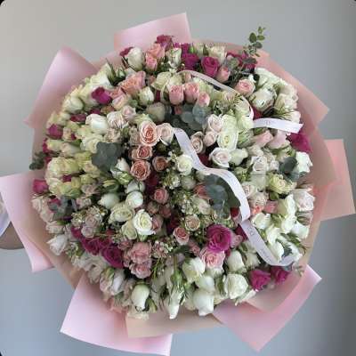 Large bouquet of pink, white, and magenta roses wrapped in pink paper