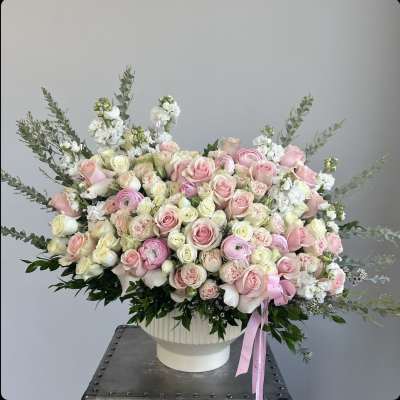 Large bouquet of pink and white roses in a white vase