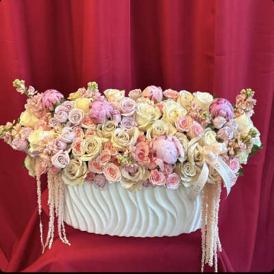 Pastel roses and peonies arranged in a white vase