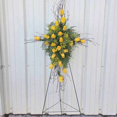 Standing cross-shaped spray of yellow roses on a metal easel.