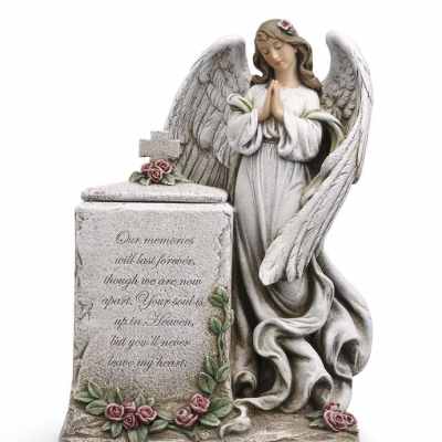 Angel memorial statue with praying figure beside stone block adorned with pink rose accents