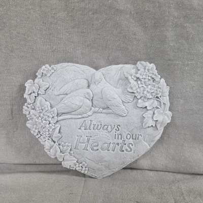 Heart-shaped stone memorial plaque with doves, carved flowers, and the words Always in our Hearts.