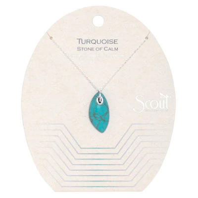 Turquoise stone pendant on a delicate silver chain displayed on a cream backing card.