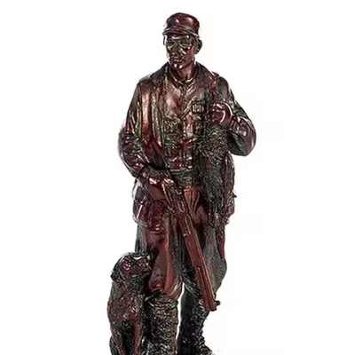 Bronze-tone figurine of a hunter with a rifle and dog by his side
