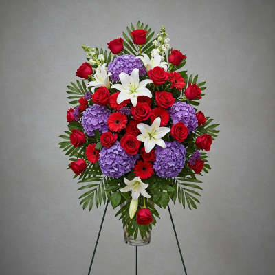 Standing floral spray with red roses, purple hydrangeas, and white lilies