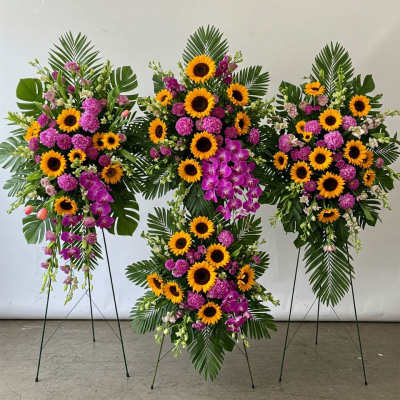 Four standing floral sprays with sunflowers and purple orchids
