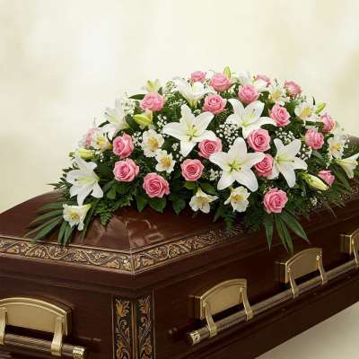 Pink roses and white lilies arranged on a casket
