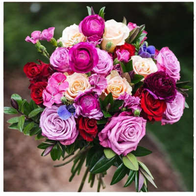 Bouquet of pink, red, and cream roses with greenery