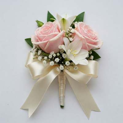 Pink rose and white lily boutonniere with a cream ribbon bow