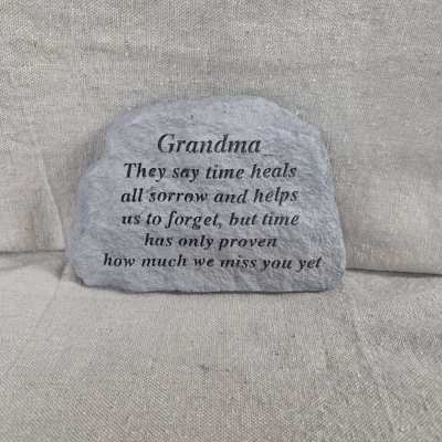 Gray memorial stone for Grandma with engraved verse on a neutral fabric background