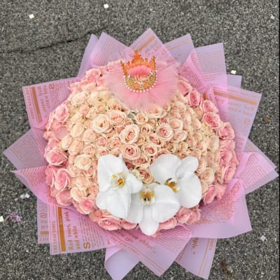 Pink rose bouquet with white orchids and a small crown topper
