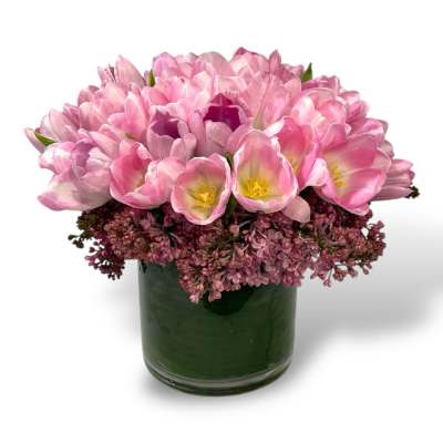 Pink tulips arranged in a dark green glass vase