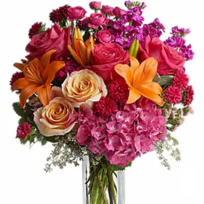 Bouquet of pink and orange flowers in a clear glass vase