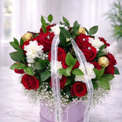 Bouquet of red roses and white carnations in a lavender box