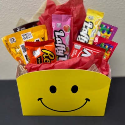Candy assortment in a yellow smiley-face gift box