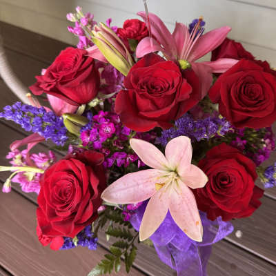 Bouquet of red roses and pink lilies with purple filler flowers