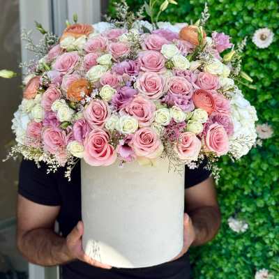 Large pink and white rose arrangement in a white hat box